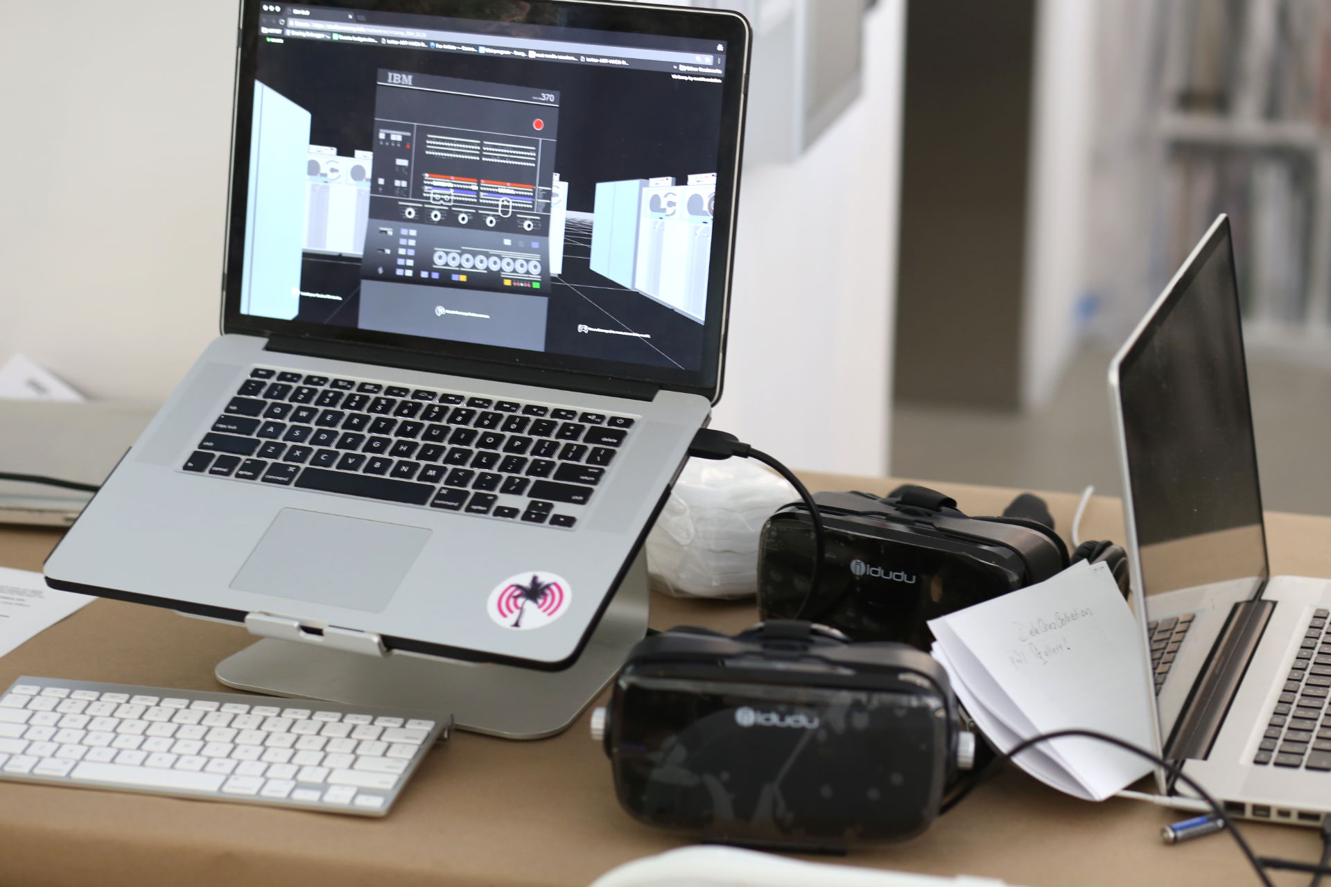 A laptop with a 3D scene opened and two Oculus on a table